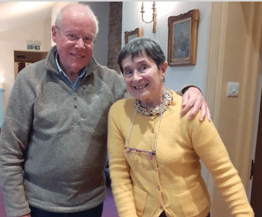 Elderly resident couple smiling in the corridor at Birtley House Nursing Home Guildford Surrey