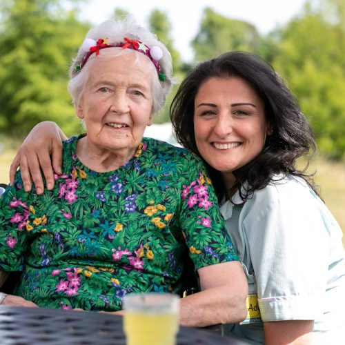 a carer with their arm around elderly resident